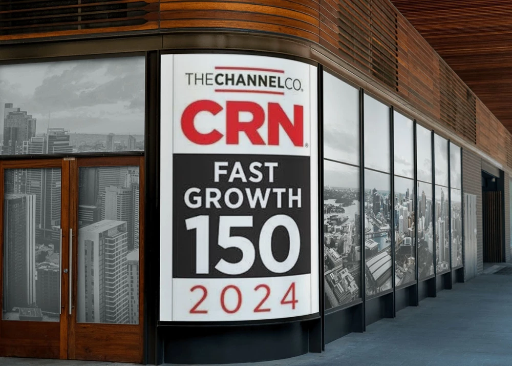 Office building exterior with large window display showing CRN Fast Growth 150 2024 logo against a backdrop of city skyline images.