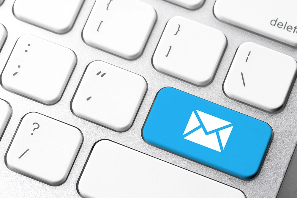 Keyboard with blue email key symbolizing Microsoft support via email.