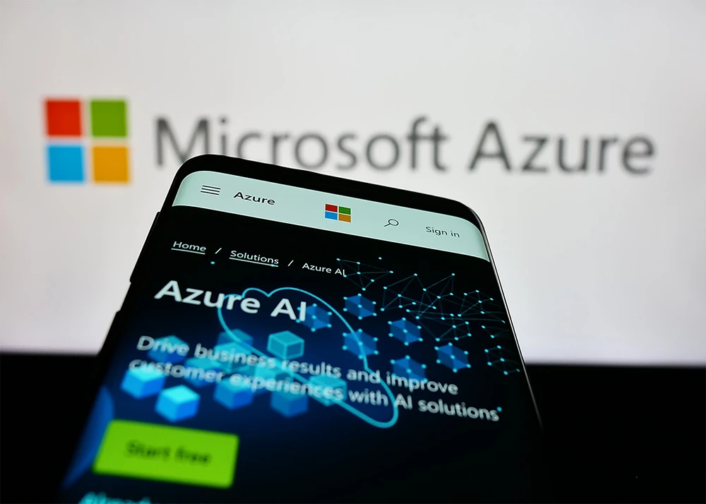Mobile phone with webpage of cloud computing platform Microsoft Azure on screen in front of business logo