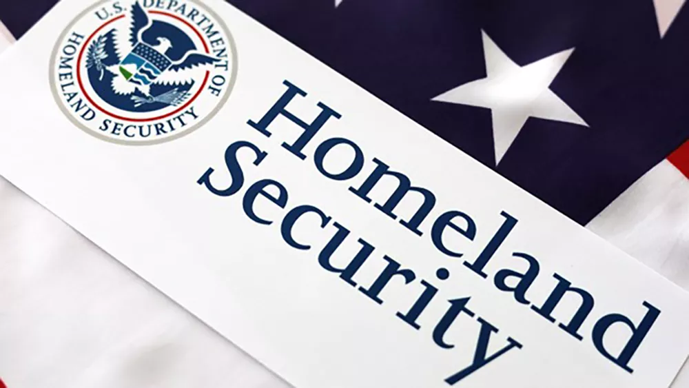 A sign for the U.S. Department of Homeland Security with an American flag background.