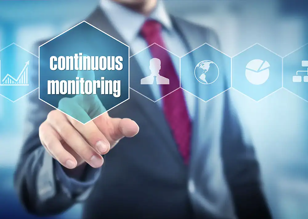 Businessman pressing "continuous monitoring" on a digital screen.